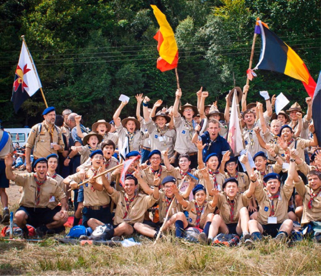 Group of young Scout d'Europa FSE exults with flags, celebrating unity and friendship.